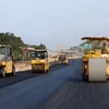 Nhà thầu huy động máy móc, nhân lực để thảm những mét bê tông nhựa trên đoạn tuyến cao tốc. (Ảnh: Việt Hùng/Vietnam+)