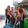 Lực lượng chức năng hướng dẫn, giúp ngư dân xã Hải Thịnh (Ninh Bình) phòng chống bão. (Ảnh: Thái Thuần/TTXVN)