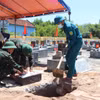 Việc khai quật phần mộ lấy mẫu trong điều kiện nắng nóng gay gắt, khắc nghiệt. (Ảnh: Phạm Cường/TTXVN)