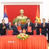 Trưởng Ban Tổ chức Trung ương Nguyễn Duy Ngọc và Trưởng Ban Tổ chức Trung ương Đảng Nhân dân Cách mạng Lào Sisay Leudetmounsone trao Thỏa thuận hợp tác giữa hai cơ quan. (Ảnh: Phương Hoa/TTXVN)