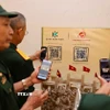 Các cựu chiến binh quét mã QR để xem triển lãm 3D trực tuyến “Hỡi đồng bào Thủ đô”. (Ảnh: Thanh Tùng/TTXVN)