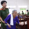 Lực lượng Công an hỗ trợ thân nhân các liệt sỹ đến lấy mẫu ADN tại Vĩnh Long. (Ảnh: Lê Thúy Hằng/TTXVN)