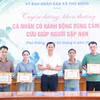 Lãnh đạo xã Phú Riềng khen thưởng cho cá nhân đã kịp thời cứu người do lũ. (Ảnh: TTXVN phát)