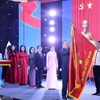 Tổng Bí thư Tô Lâm gắn Huân chương Hồ Chí Minh lên lá cờ truyền thống Thông tấn xã Việt Nam. (Ảnh: Lâm Khánh/TTXVN)