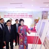 Tổng Giám đốc TTXVN Vũ Việt Trang giới thiệu trưng bày ảnh chuyên đề "100 năm Báo chí cách mạng Việt Nam" với các đại biểu dự hội thảo. (Ảnh: Phương Hoa/TTXVN)