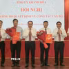 Thường trực Tỉnh ủy Khánh Hòa trao quyết định và tặng hoa chúc mừng ông Tạ Hồng Quang (bên trái) và nhà báo Lê Hoàng Triều (bên phải). (Ảnh: Xuân Triệu/TTXVN)