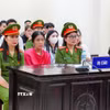 Bị cáo Nguyễn Thị Bình (áo hồng, giữa) tại phiên tòa. (Ảnh: Kim Anh/TTXVN)
