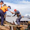 Cảnh sát hỗ trợ ngư dân lên khỏi tàu cá để tránh bão Bavi tại Trung Quốc ngày 9/7/2026. (Ảnh: THX/TTXVN phát)