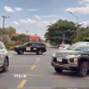 2 chiếc xe ngang nhiên đậu so le trên cả 2 chiều, chặn đường để đoàn xe doanh nhân băng qua Quốc lộ 20. (Ảnh: TTXVN phát)