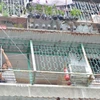 Một hộ dân cư xá Thanh Đa thuê thợ sắt tháo dỡ “chuồng cọp” ở ban công. (Ảnh: Linh Sơn/TTXVN)