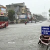 Tuyến đường huyết mạch Nguyễn Trãi, phường Hạc Thành, tỉnh Thanh Hóa ngập, phải dựng biển cảnh báo cho phương tiện tham gia giao thông. (Ảnh: Việt Hoàng/TTXVN)