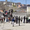 Người di cư trèo qua hàng rào biên giới để vào vùng lãnh thổ Ceuta của Tây Ban Nha từ thành phố Fnideq, Maroc. (Ảnh: THX/TTXVN phát)