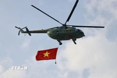 Cờ Tổ quốc tung bay trên bầu trời. (Ảnh: Lê Xuân/TTXVN)