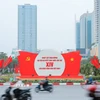 Khẩu hiệu, biểu trưng Đại hội nổi bật giữa dòng xe qua lại trên đường phố Hà Nội. (Ảnh: Lê Đông/TTXVN)