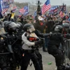 Người biểu tình xung đột với cảnh sát chống bạo động tại Đồi Capitol ở Washington D.C., ngày 6/1/2021. (Ảnh: AFP/TTXVN)
