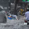 Một người dân bị ngã trên đường Quốc Hương khi di chuyển qua đoạn đường ngập. (Ảnh: TTXVN phát)