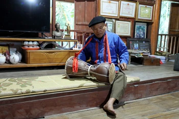 Nghệ nhân Nhân dân Sầm Văn Dừn biểu diễn trống sành nhạc cụ truyền thống của đồng bào dân tộc Cao Lan. (Ảnh: Quang Cường/TTXVN)