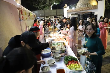 Bà con cộng đồng người Việt tại Ai Cập và bạn bè quốc tế thưởng thức các món ăn truyền thống của Việt Nam. (Ảnh: Nguyễn Trường/TTXVN)