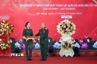 Thượng tá Trần Thị Anh Thư, Giám đốc Bảo tàng Quân khu 5 (trái) tiếp nhận các hiện vật được trao tặng tại buổi tổng kết. (Ảnh: Trần Lê Lâm/TTXVN)