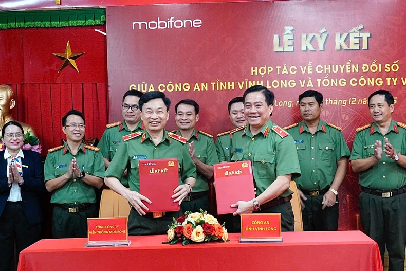 Thiếu tướng Trương Sơn Lâm - Chủ tịch MobiFone và Thiếu tướng Nguyễn Thanh Hải - Giám đốc Công an tỉnh Vĩnh Long trao văn bản hợp tác. (Ảnh: PV/Vietnam+)