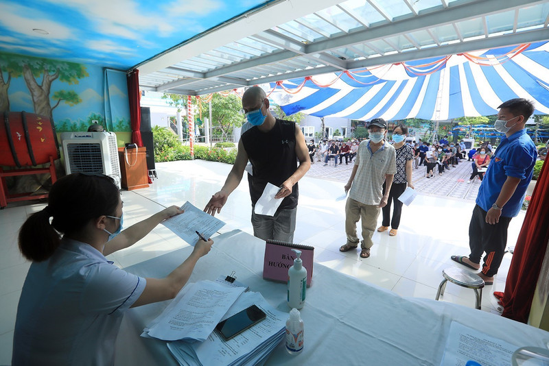 Nhân viên y tế hướng dẫn người dân đến tiêm vaccine. Ảnh: Phan Tuấn Anh/TTXVN)