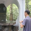 Du khách thắp hương nhà bia Thông tấn xã Giải phóng, tỉnh Đồng Nai. (Ảnh: Công Phong/TTXVN)