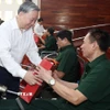 Tổng Bí thư Tô Lâm thăm hỏi và tặng quà cho thương bệnh binh. (Ảnh: Thống Nhất/TTXVN)