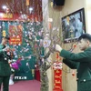 Cán bộ, chiến sỹ Đồn Biên phòng Cửa khẩu quốc tế Hữu Nghị (Lạng Sơn) chăm sóc, trang trí cây đào Tết tại đơn vị. (Ảnh: Quang Duy/TTXVN)