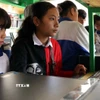 Các em học sinh vùng cao sử dụng máy tính có kết nối internet trên xe thư viện lưu động. (Ảnh: Hữu Quyết/TTXVN)