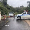 Lực lượng chức năng chốt chặn không cho người và phương tiện qua lại nơi sạt lở trên đèo Ngoạn Mục. (Ảnh: TTXVN phát)