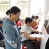 Người dân thao tác quét VNeID để làm thủ tục hành chính tại Trung tâm Phục vụ Hành chính công xã Củ Chi. (Ảnh: Hữu Duyên/TTXVN)