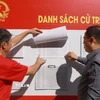 Cử tri phường Nam Nha Trang, tỉnh Khánh Hòa xem danh sách cử tri niêm yết tại khu vực bỏ phiếu bầu cử. (Ảnh: Xuân Triệu/TTXVN)