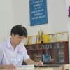 Đoàn Thanh Tùng học tập tại thư viện nhà trường. (Ảnh: Phan Sáu/TTXVN)