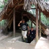 Khách quốc tế tham quan hầm nghỉ ngơi và làm việc của Phó Chính ủy ở địa đạo Củ Chi. (Ảnh: Hồng Đạt/TTXVN)