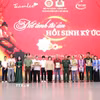 Lãnh đạo Thành ủy, Bộ Tư lệnh Thành phố, Công an Thành phố cùng nhóm phục dựng ảnh "Team Lee" trao tặng di ảnh liệt sỹ đã phục dựng cho thân nhân các liệt sỹ. (Ảnh: Xuân Khu/TTXVN)