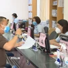 Người dân đến làm thủ tục hành chính tại bộ phận một cửa phường Hiệp Thành (Quận 12, Thành phố Hồ Chí Minh). (Ảnh: TTXVN phát)