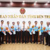 Trao Nghị quyết của Hội đồng Nhân dân tỉnh Bến Tre cho đại diện các cơ quan hợp nhất, sáp nhập. (Ảnh: Huỳnh Phúc Hậu/TTXVN)