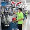 Công nhân nhà máy Sung Hwa Vina (vốn Hàn Quốc) tại Khu Công nghiệp Hòa Bình (Tây Ninh) kiểm tra sợi trên máy dệt tất. (Ảnh: Minh Hưng/TTXVN)
