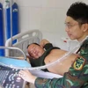 Bác sỹ Trung tâm y tế thị trấn Trường Sa siêu âm ổ bụng cho bệnh nhân Võ Sỹ Danh. (Ảnh: TTXVN phát)