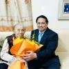 Thủ tướng Phạm Minh Chính thăm, chúc mừng nguyên Phó Chủ tịch nước Nguyễn Thị Bình nhân Ngày Quốc tế Phụ nữ 8/3. (Ảnh: Dương Giang/TTXVN)