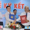 Ông Võ Khắc Thái (trái), Phó Chủ tịch Thường trực Liên đoàn Lao động Thành phố Hồ Chí Minh cùng ông Võ Hồng Tài, Quyền Tổng Giám đốc Công ty IPC (phải) thực hiện nghi thức ký kết hợp tác xây nhà ở xã hội. (Ảnh: Thanh Vũ/TTXVN)