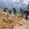 Cán bộ, chiến sỹ dọn dẹp đất đá, cây cối đổ gãy, khôi phục các tuyến giao thông tại xã Mù Cang Chải. (Ảnh: TTXVN phát)