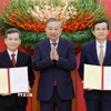 Tổng Bí thư Tô Lâm trao Quyết định của Bộ Chính trị cho các đồng chí Lê Minh Trí (bên trái) và Đoàn Minh Huấn (bên phải). (Ảnh: Thống Nhất/TTXVN)