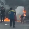 Người dân dùng bình chữa cháy cứu nạn nhân. (Ảnh: TTXVN phát)