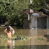 Người dân di chuyển qua vùng ngập lụt. (Ảnh: Tường Quân/TTXVN)