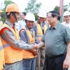 Thủ tướng Phạm Minh Chính với công nhân thi công dự án Đường tỉnh ĐT.975 (đoạn từ ĐT 973 - Cảng Hàng không Phú Quốc). (Ảnh: Dương Giang/TTXVN)