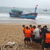Lực lượng chức năng và người dân địa phương hỗ trợ cứu nạn tàu cá BĐ 97820 TS. (Ảnh: TTXVN phát)