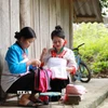 Phụ nữ dân tộc Mảng may những bộ trang phục truyền thống. (Ảnh: Quý Trung/TTXVN)