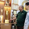 Cựu chiến binh Phan Trọng Điền (trái) giới thiệu sản phẩm đúc đồng của công ty. (Ảnh: Nguyễn Lành/TTXVN)