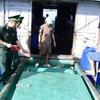 Lực lượng Biên phòng kiểm tra số dầu chờ trên tàu. (Ảnh: TTXVN phát)